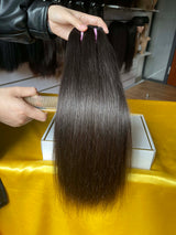 QWB Queen Weave Beauty - Product construction quality documentation showing reinforced weft attachment system. Machine double stitching anchors each hair strand to the base ensuring durability during extended wear periods. Close-up reveals minimal bulk at seam edges for comfortable lay-flat installa