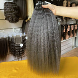 QWB Kinky Straight Tape-In Extension close-up detail shot highlighting distinctive steam-processed texture on individual weft strip approximately 2 inches wide. Natural #1b black Brazilian virgin human hair with cuticle intact showing subtle small braided/coiled pattern created by high temperature t