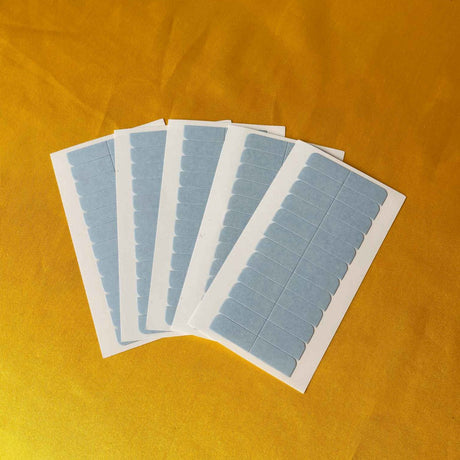 Adhesive Blue Tape Double-Sided For Tape-In Extension complete sheet display showing 12 individual adhesive strips arranged in organized grid pattern on protective backing paper. Each strip measures approximately 2 inches wide by length matching tape-in weft dimensions for full-width coverage ensuri
